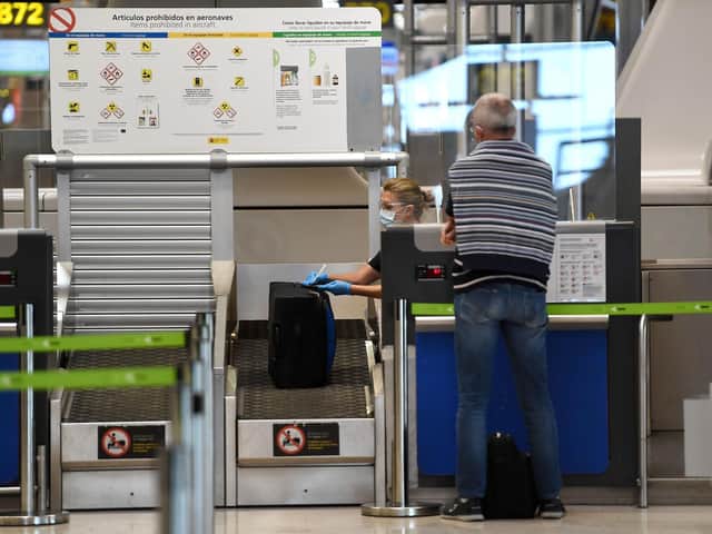 A passenger checks in for his flight at the Barajas airport in Madrid on June 20, 2020, a day before the country's state of emergency ends following a national lockdown to stop the spread of the novel coronavirus (Photo by PIERRE-PHILIPPE MARCOU/AFP via Getty Images))