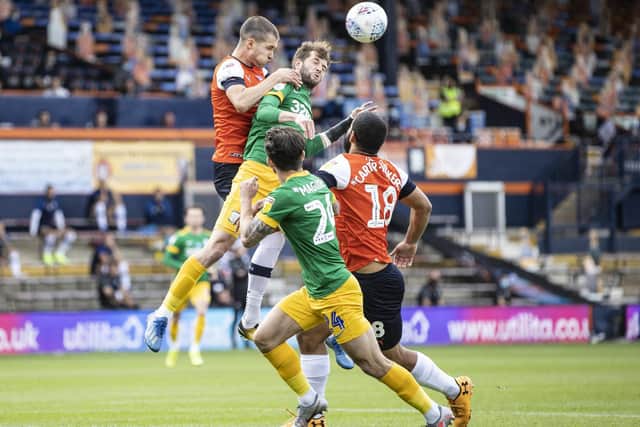 PNE winger Tom Barkhuizen competes in the air with Luton's Dan Potts