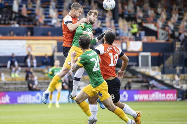 Preston North End’s Tom Barkhuizen competing with Luton Town’s Dan Potts (left)