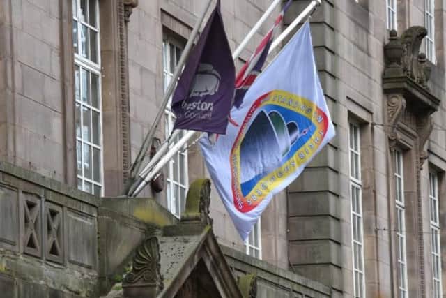 The Windrush flag flutters above the entrance to Preston Town Hall.