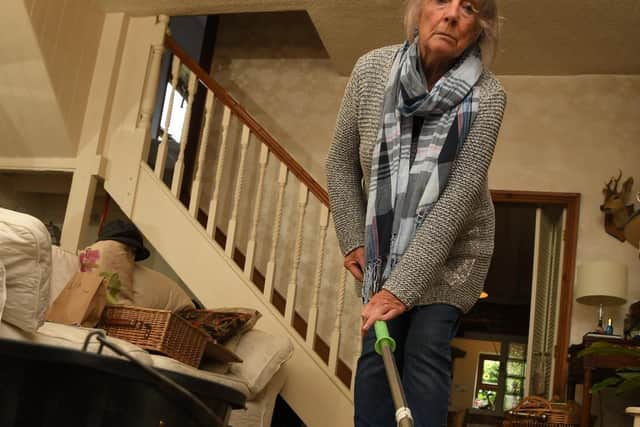 Patricia Carter mops water out of her flooded home.