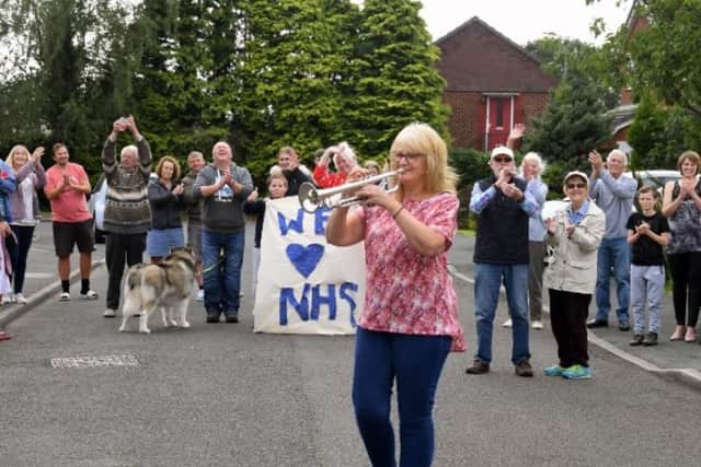Residents of North Grove, Lostock Hall applaud the health service as NHS worker Pauline Coxhead plays the trumpet to mark the 72nd birthday.