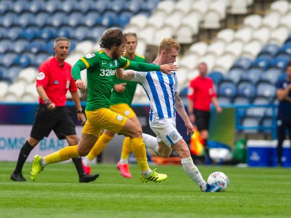 Preston midfielder Ben Pearson tries to prevent a Huddersfield attack