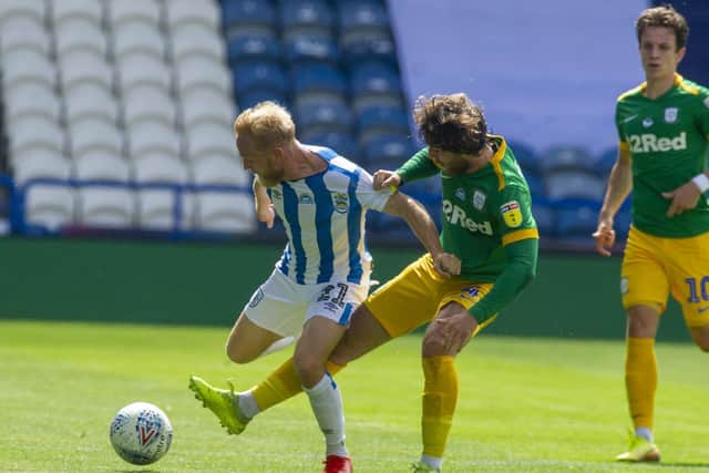 PNE midfielder Ben Pearson tackles Huddersfield's Alex Pritchard
