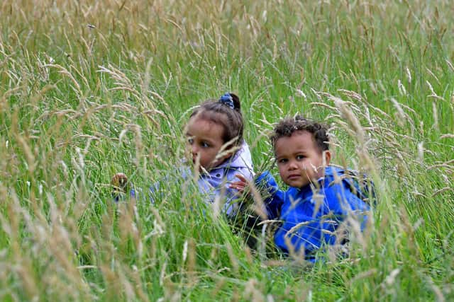 Local children in the grass, that hasn't been cut since March.