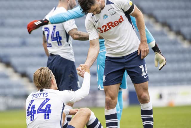PNE left-back Andrew Hughes helps Brad Potts up at the final whistle
