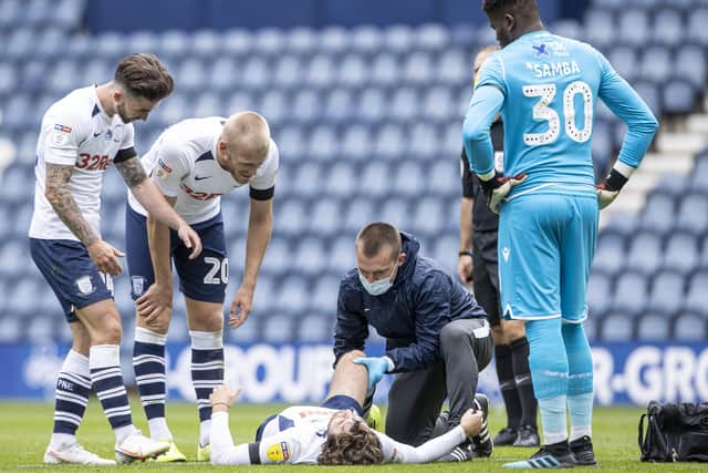 Preston North End's Sean Maguire (left) and Jayden Stockley (2nd left) check on injured team mate Ben Pearson