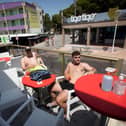 Two tourists sit at a bar on Punta Ballena street in Magaluf on the Spanish island of Mallorca  (Photo by JAIME REINA/AFP via Getty Images)