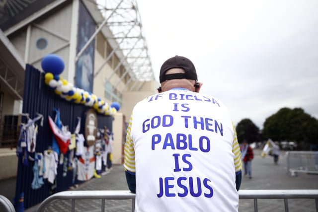 A Leeds fan wears a shirt with 'Bielsa is Jesus' written on the back.