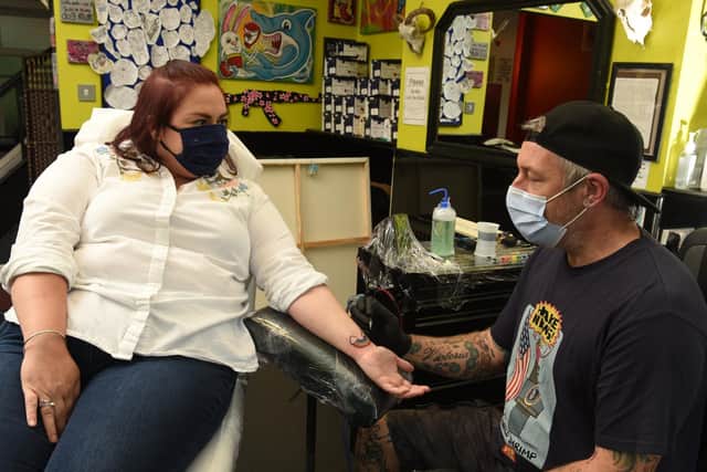 Tattoo artist Stu Allen completing the work