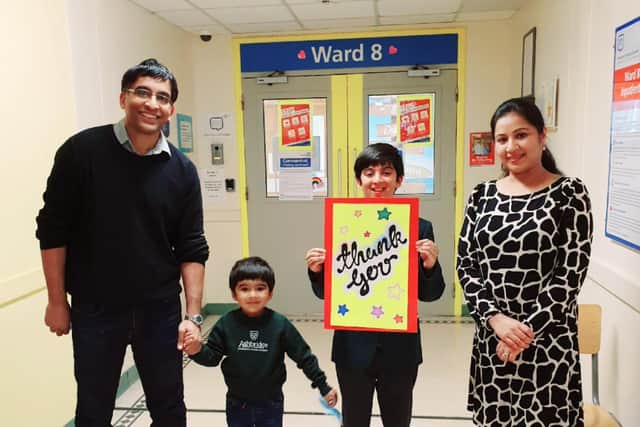Ahaan and his family with a thank you card