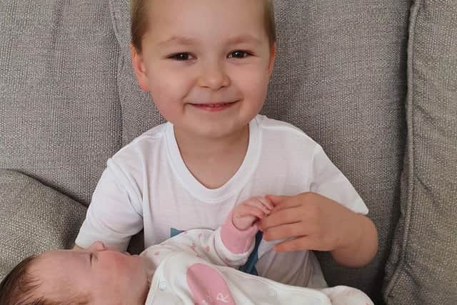 Owen holding his newborn baby sister Chloe.