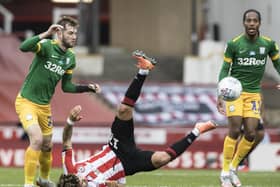 Preston North End's Tom Barkhuizen watches as Brentford midfielder Emiliano Marcondes takes a tumble at Griffin Park