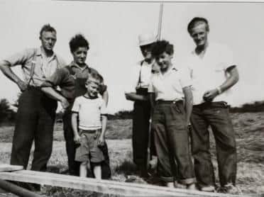 Hay time at Above Beck Farm, circa 1950s. From left: George Stephenson, Harry Chesters, a young Richard (Dick) Stephenson, Jimmy Stephenson (Richard's father), Winnie Stephenson, Herbert Pritchard. The timber structure could be a bale sledge.Bailing machines pulled by a tractor were in use by this time making the harvesting of hay much easier.