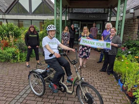 Sue Brown arrives at the hospice at the end of her virtual trike ride for the charity.