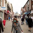 Pedestrians wear facemasks as they walk through a pedestriansed street in Oldham, Greater Manchester (Photo by OLI SCARFF/AFP via Getty Images)
