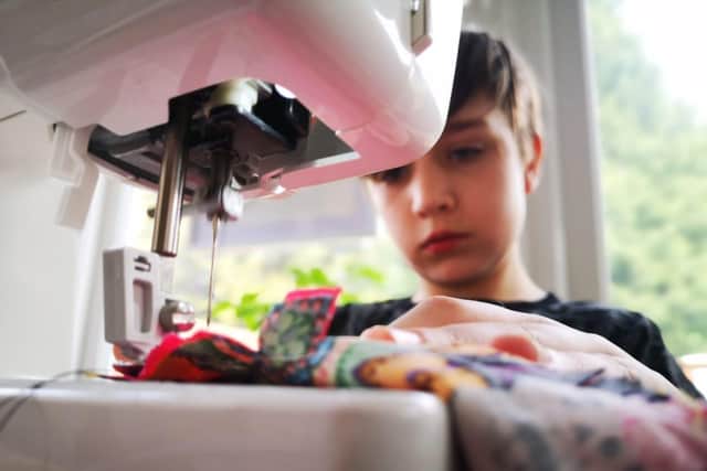 Millie at work sewing her cotton masks together.