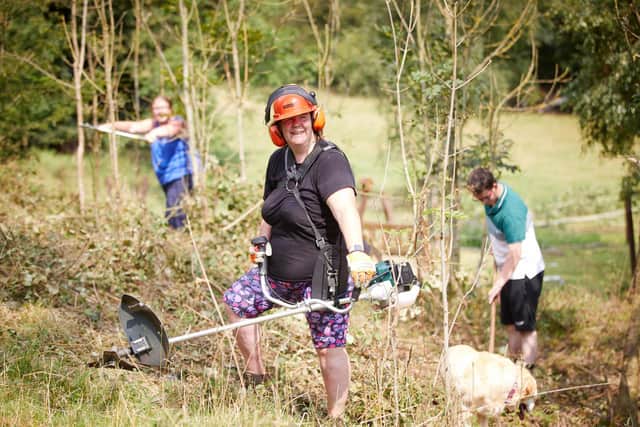 David Wilson Homes  have donated money to The Girl Guides in Preston to buy tools for them to clear shrubs at their campsite in Silverdale, Lancashire.
Pictured volunteer Elaine Clare using the strimmer  bought with the donation