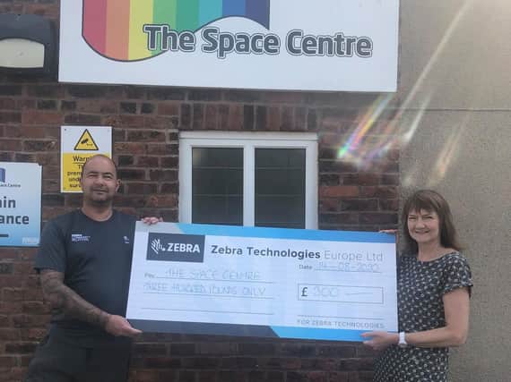 The handover of the £300 donation from Zebra Technologies