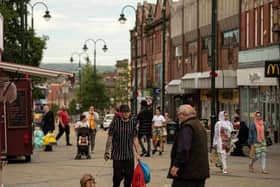Shoppers make their way through the town centre in Oldham