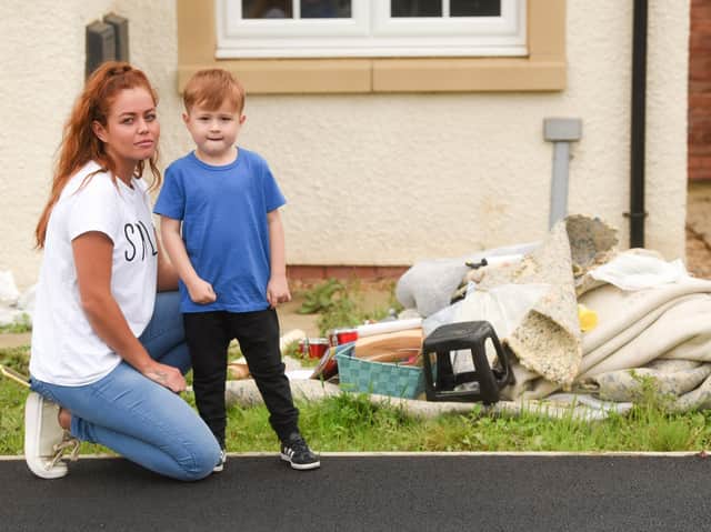 Leanne Bishop, with son Rowan, inspects the damage at her Kirkham home