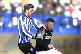 Josh Windass competes for the ball with Derby's Wayne Rooney while on loan at Sheffield Wednesday