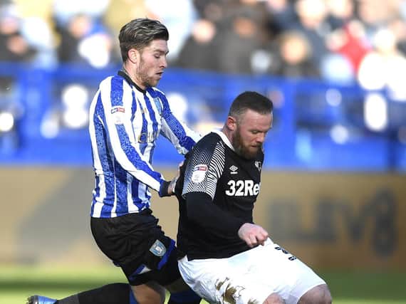 Josh Windass competes for the ball with Derby's Wayne Rooney while on loan at Sheffield Wednesday
