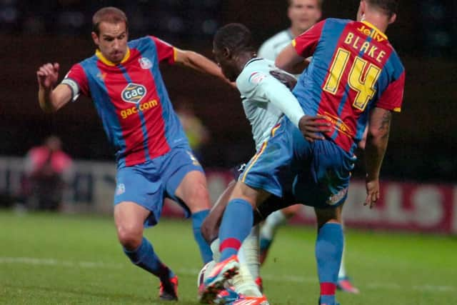 Jeffrey Monakana battles for possession against two Crystal Palace players