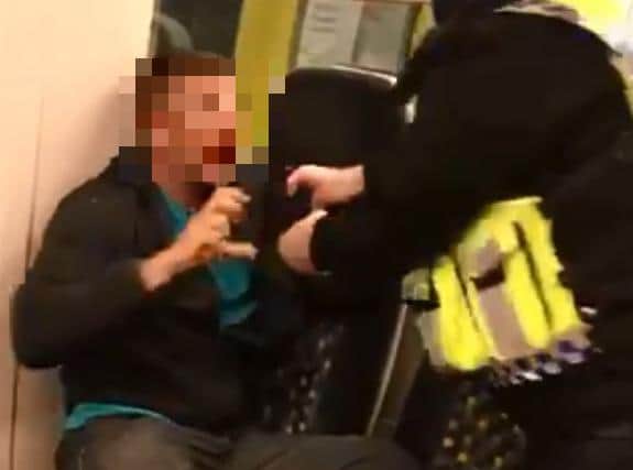 The officer then sprays pepper or PAVA spray into the man's face before handcuffing him and dragging him off the train