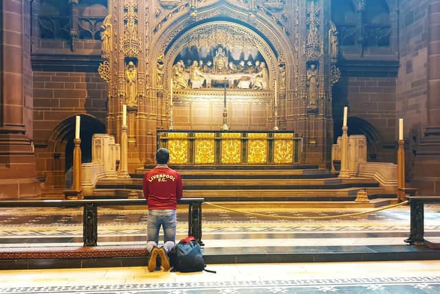 Is football an obsession?  A fan praying in the Liverpool Cathedral St.James