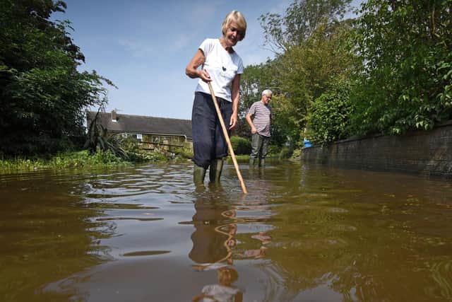 Neighbours Julie Sipson and Alan Brewer clear up after the floods hit Lower Lane, Freckleton