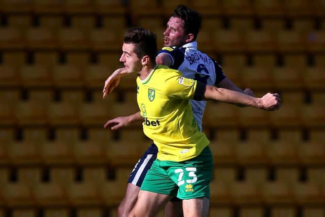 Preston North End midfielder challenges Norwich's Kenny McLean in the air at Carrow Road