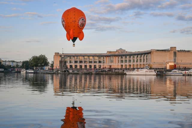 A reflection on the water during the maiden flight of a hot air balloon shaped as Wallace and Gromit's Moon Rocket