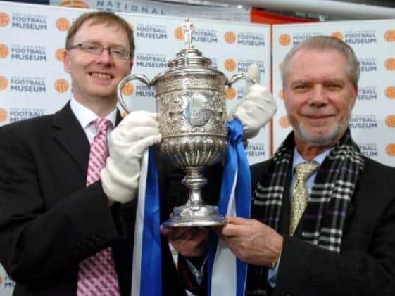 David Gold (right) hands over the FA Cup in Preston to National Football Museum director Kevin Moore in 2006.