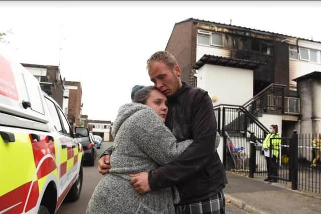 Rachel Roberts and partner Adam Young outside their burnt-out flat.
