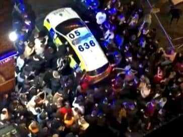 Crowds surrounded police cars after officers were called to disperse revellers outside pubs and clubs in Liverpool city centre last night (Tuesday, October 13)