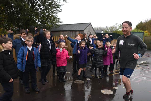 Youngsters braved the rain to cheer headteacher Stephen Draper as he ran into Banks Methodist Primary School