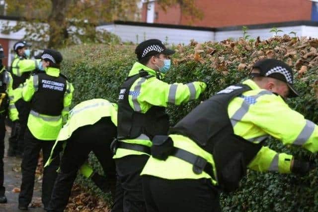Officers search hedges for weapons as part of Operation Sceptre