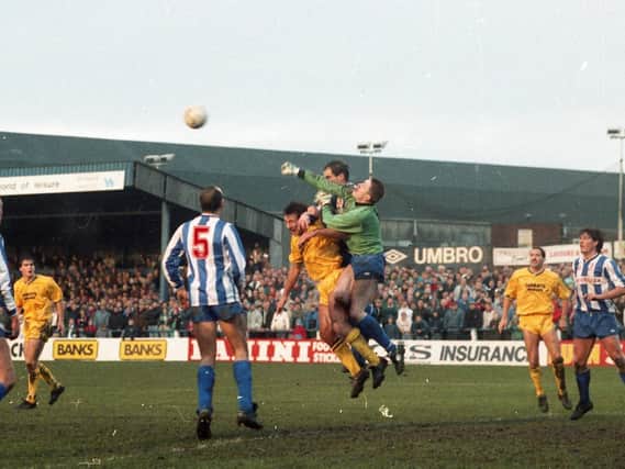 The Whitley Bay goalkeeper punches clear under pressure from Preston North End midfielder Warren Joyce in PNE's FA Cup defeat at Hillheads Park