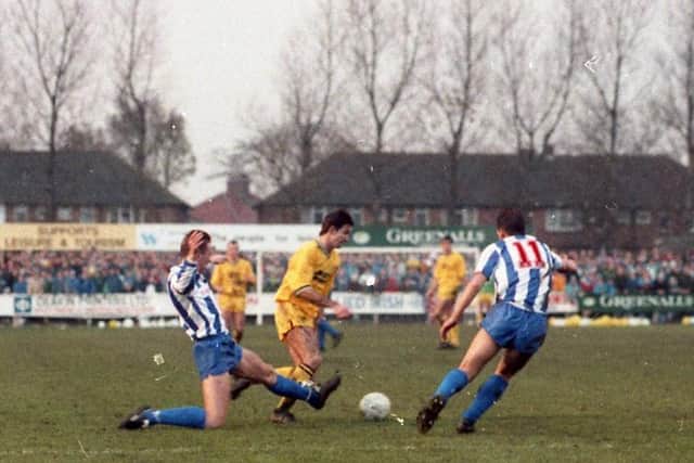 Brian Mooney tries to find a way through the Whitley Bay defence - the PNE fans are in the background
