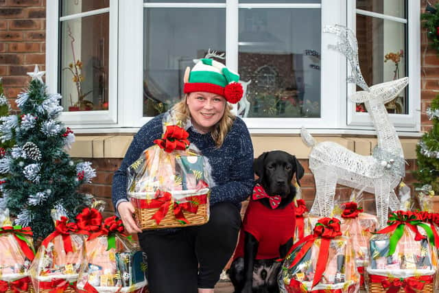 Lottery winner Ruth Breen, from Wigan, poses with her dog as she shows-off ten Christmas hampers she’s made for carers with Age Concern Central Lancashire. Picture: Anthony Devlin