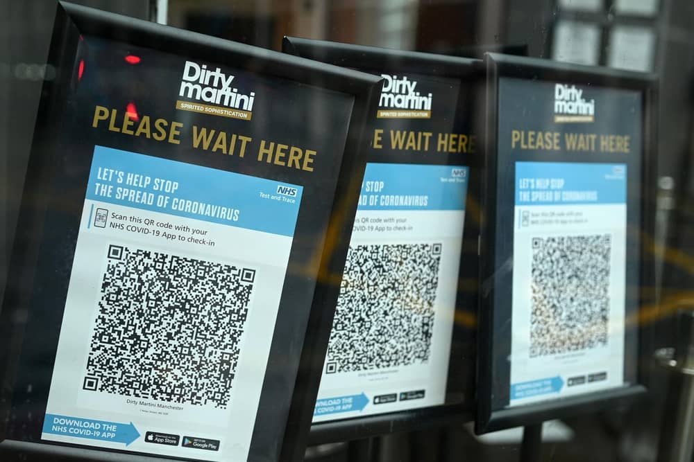 Track and trace QR codes are displayed outside a pub, in Manchester