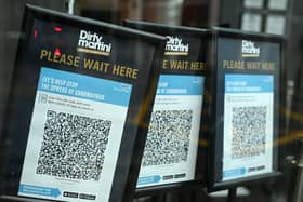 Track and trace QR codes are displayed outside a pub, in Manchester