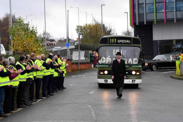 A Fishwick's bus drives past clapping colleagues