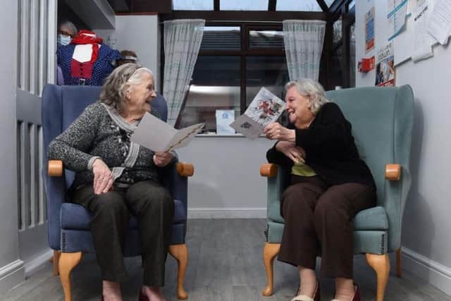 Brookside residents Betty Snape and Ann Trowbridge laugh with their Christmas cards