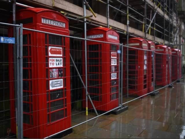 Fenced in - Preston landmark red phone boxes.