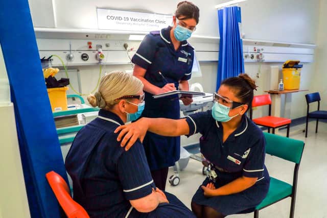 Wearing a protective face coverings to combat the spread of the coronavirus, Matron May Parsons is assessed by Victoria Parker during training in the Covid-19 Vaccination Clinic