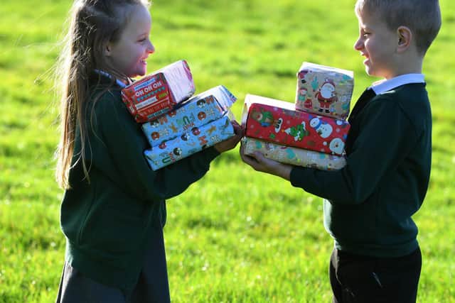Tomasz and Amelia with some of the presents at Ingol Community Primary School toy appeal