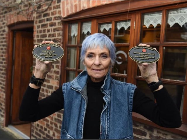 Kath Almond with two of the 48 hero plaques.