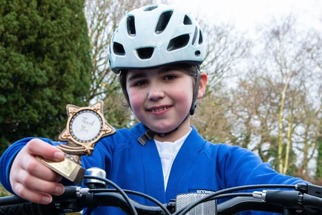 Super cyclist and fundraiser Erin, pictured with her thank you trophy